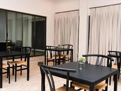 a room with black tables and chairs and a mirror at Sou House in Louis Trichardt
