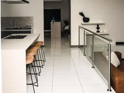 a kitchen with a white floor and a counter with stools at Sou House in Louis Trichardt