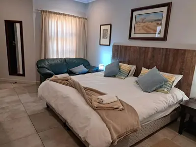 a bedroom with a large bed with blue pillows at Bushveld Magic in Klipdrift