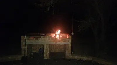 a brick fireplace at night with fire in it at Bushveld Magic in Klipdrift