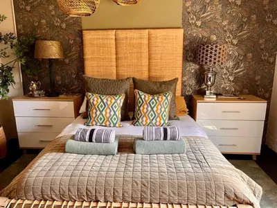 a bedroom with a large bed with pillows at A Bird Cage Stay & Cottage in Haenertsburg