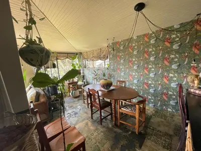 a dining room with a table and chairs and a wall at A Bird Cage Stay & Cottage in Haenertsburg