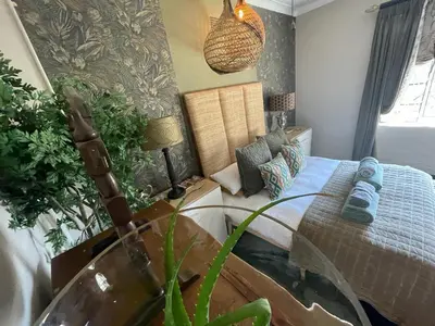 a bedroom with a bed and a table with plants at A Bird Cage Stay & Cottage in Haenertsburg