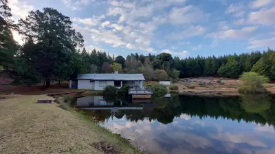 a house sitting next to a body of water at Lake House in Dullstroom