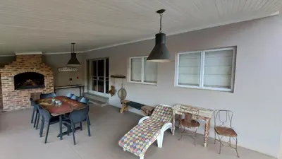a living room with a table and chairs and a fireplace at Lake House in Dullstroom