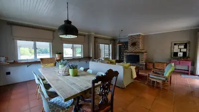a dining room and living room with a table and chairs at Lake House in Dullstroom