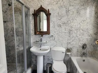 a bathroom with a toilet and a sink and a shower at Waterkloof Mansion Boutique Hotel in Pretoria