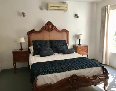 a bedroom with a large bed with two night stands at Waterkloof Mansion Boutique Hotel in Pretoria