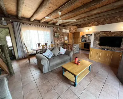 a living room with a couch and a table at Intundla's Rest in Marloth Park
