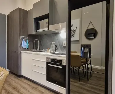 a kitchen with a stove top oven next to a table at Top Floor Penthouse - Overlooking Times Square Casino in Pretoria