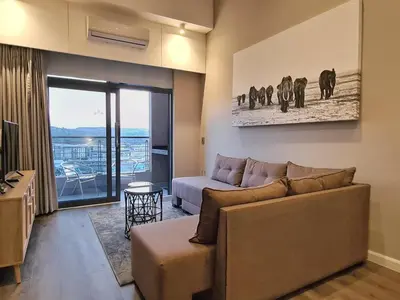a living room with a couch and a table at Top Floor Penthouse - Overlooking Times Square Casino in Pretoria