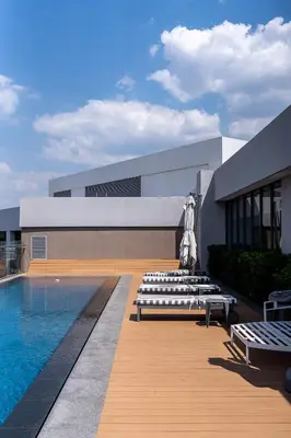 a building with a swimming pool with benches next to it at Top Floor Penthouse - Overlooking Times Square Casino in Pretoria