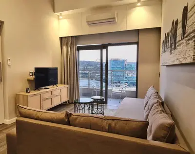a living room with a couch and a television at Top Floor Penthouse - Overlooking Times Square Casino in Pretoria