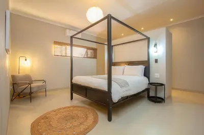 a bedroom with a canopy bed and a chair at Cheetah's Run in Marloth Park