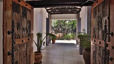 a hallway with wooden doors and potted plants at Khayalami Hotel - Mbombela in Nelspruit