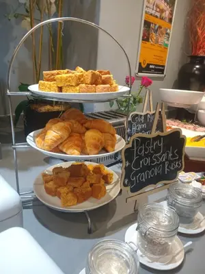 a display with three tiers of breads and pastries on plates at Khayalami Hotel - Mbombela in Nelspruit