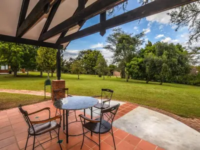 a patio with a table and chairs and a field at Penny's Place on Greenway in White River