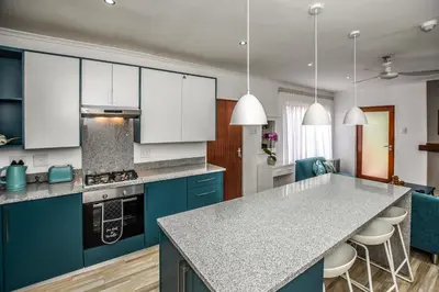 a kitchen with blue cabinets and a counter top at Penny's Place on Greenway in White River