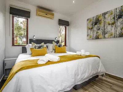 a bedroom with a large white bed with yellow pillows at Penny's Place on Greenway in White River