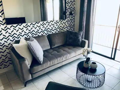 a living room with a couch and a table at Taina Apartment @ Green Creek in Pretoria