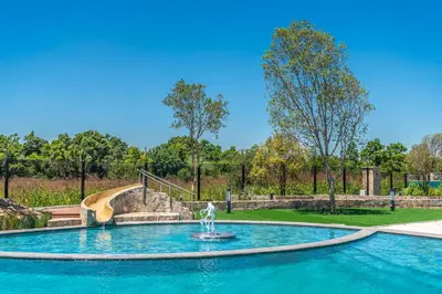 a fountain in the middle of a pool with a slide at Taina Apartment @ Green Creek in Pretoria