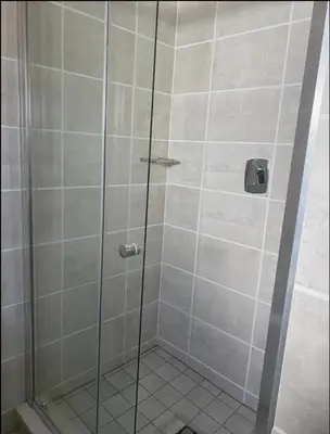 a shower with a glass door in a bathroom at Taina Apartment @ Green Creek in Pretoria