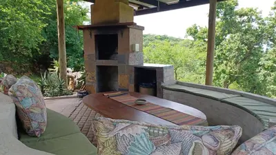 a outdoor patio with a fireplace and a table at InnibosRus Self-catering in White River