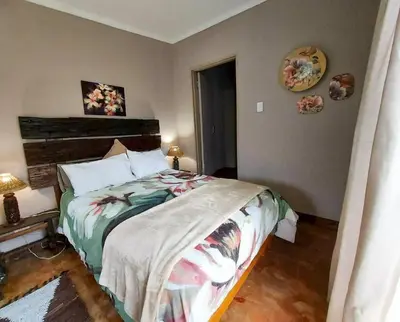 a bedroom with a large bed in a room at InnibosRus Self-catering in White River