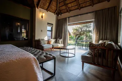 a bedroom with a bed and a large window at Lapeng Guest Lodge in Burgersfort