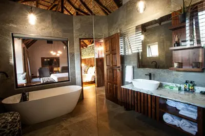a bathroom with a tub and a sink and a mirror at Lapeng Guest Lodge in Burgersfort