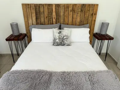 a large bed with two night stands next to it at Pan's Breeze Overnight Accommodation in Dalmada AH