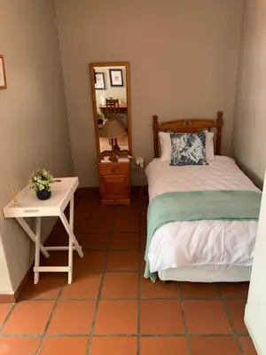 a bedroom with a bed and a table and a mirror at Barnyard Venue in Ermelo