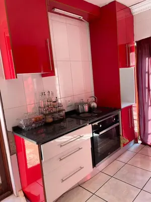 a kitchen with red cabinets and a black and white stove at Royal Views in Hartbeespoort