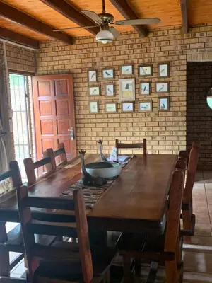 a dining room with a wooden table and chairs at Shebamona No loadshedding in Marloth Park