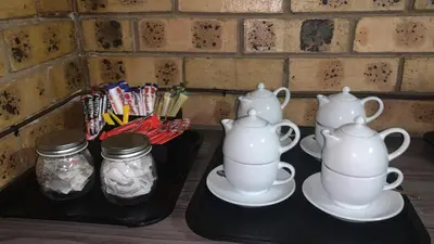 two teapots and jars on a tray on a table at Shebamona No loadshedding in Marloth Park