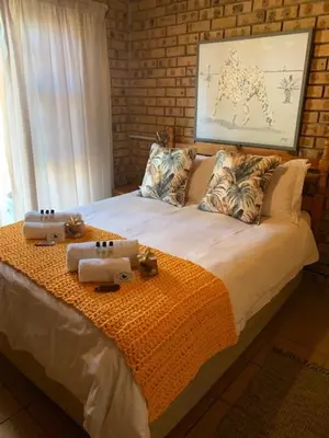 a bedroom with a bed with two towels on it at Shebamona No loadshedding in Marloth Park