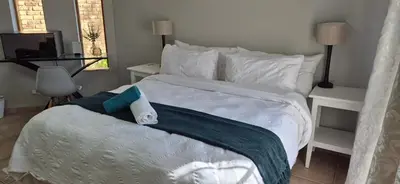 a white bed with a towel on top of it at 19th on Bloekom Guesthouse in Secunda