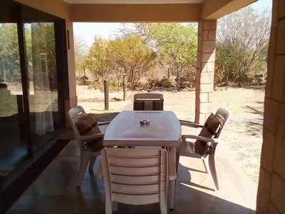 a dining room with a table and chairs and a window at Nyani Lodge Dinokeng in Pretoria