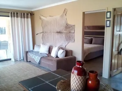 a living room with a couch and a bed at Nyani Lodge Dinokeng in Pretoria