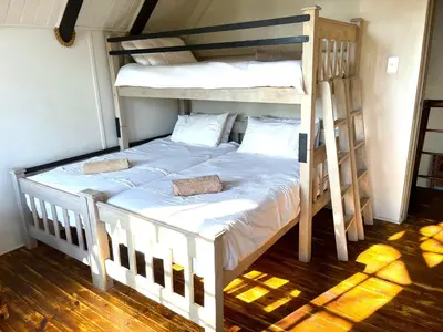 a bedroom with two bunk beds and a ladder at Fish Eagle Villa in Hoedspruit