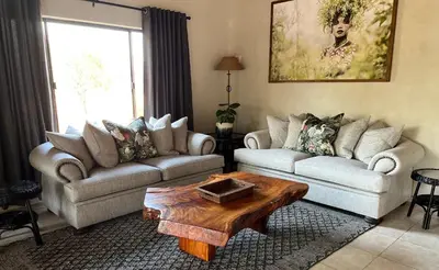 a living room with two couches and a coffee table at Fish Eagle Villa in Hoedspruit