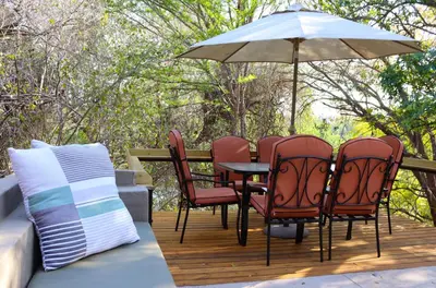 a table and chairs with an umbrella on a deck at Fish Eagle Villa in Hoedspruit