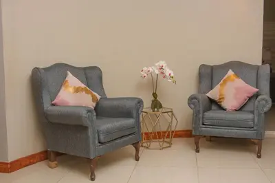 two chairs and a vase of flowers in a room at Senaville Guesthouse in Louis Trichardt