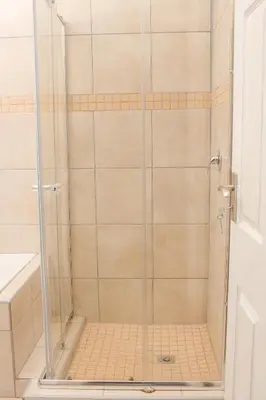 a shower with a glass door in a bathroom at Senaville Guesthouse in Louis Trichardt