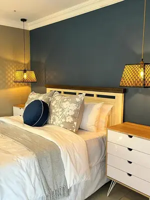 a bedroom with a bed with a blue wall at Senaville Guesthouse in Louis Trichardt