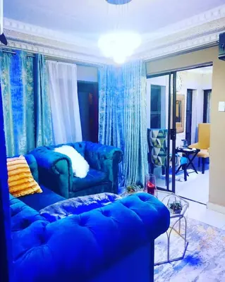 a blue couch in a living room with blue curtains at Ko-Porch luxury guest house in Polokwane