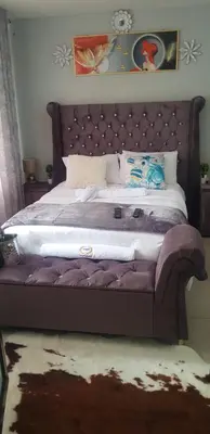 a bedroom with a large bed with a padded headboard at Ko-Porch luxury guest house in Polokwane