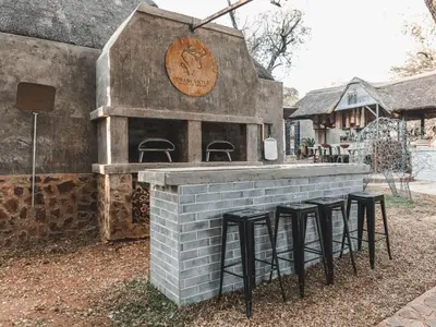a brick bar with stools in front of a building at Thaba eNtle Private Boutique Game Farm in Thabazimbi