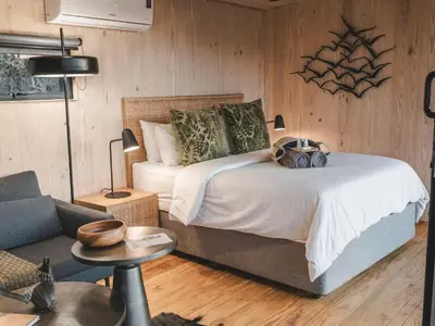 a bedroom with a bed and a couch and a chair at Thaba eNtle Private Boutique Game Farm in Thabazimbi
