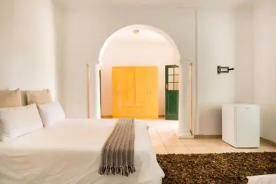 a bedroom with a white bed and a yellow door at 54 Brecher in Pretoria